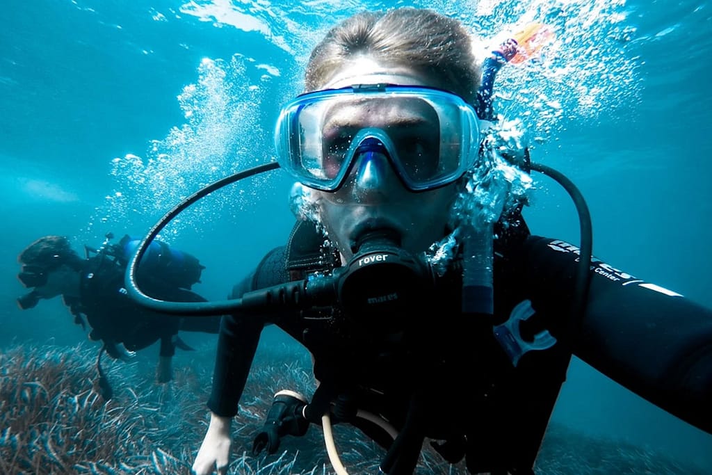 phi-phi-cabana-diving-resuce-diver-panel-5 A selfie of two divers, a girl and a guy swimming and exploring the underwater of Phi Phi Island