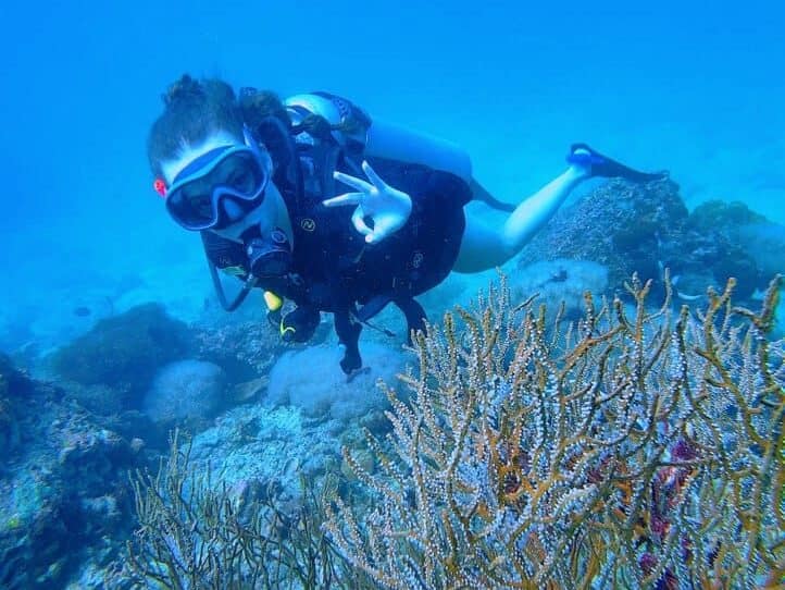 A happy diver and stunning colorful corals underwater in phi phi island