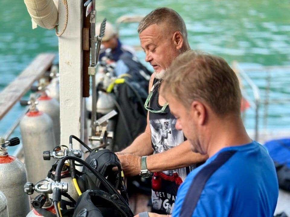 Two scuba diving instructors preparing the gear for the first time scuba diving in koh phi phi island